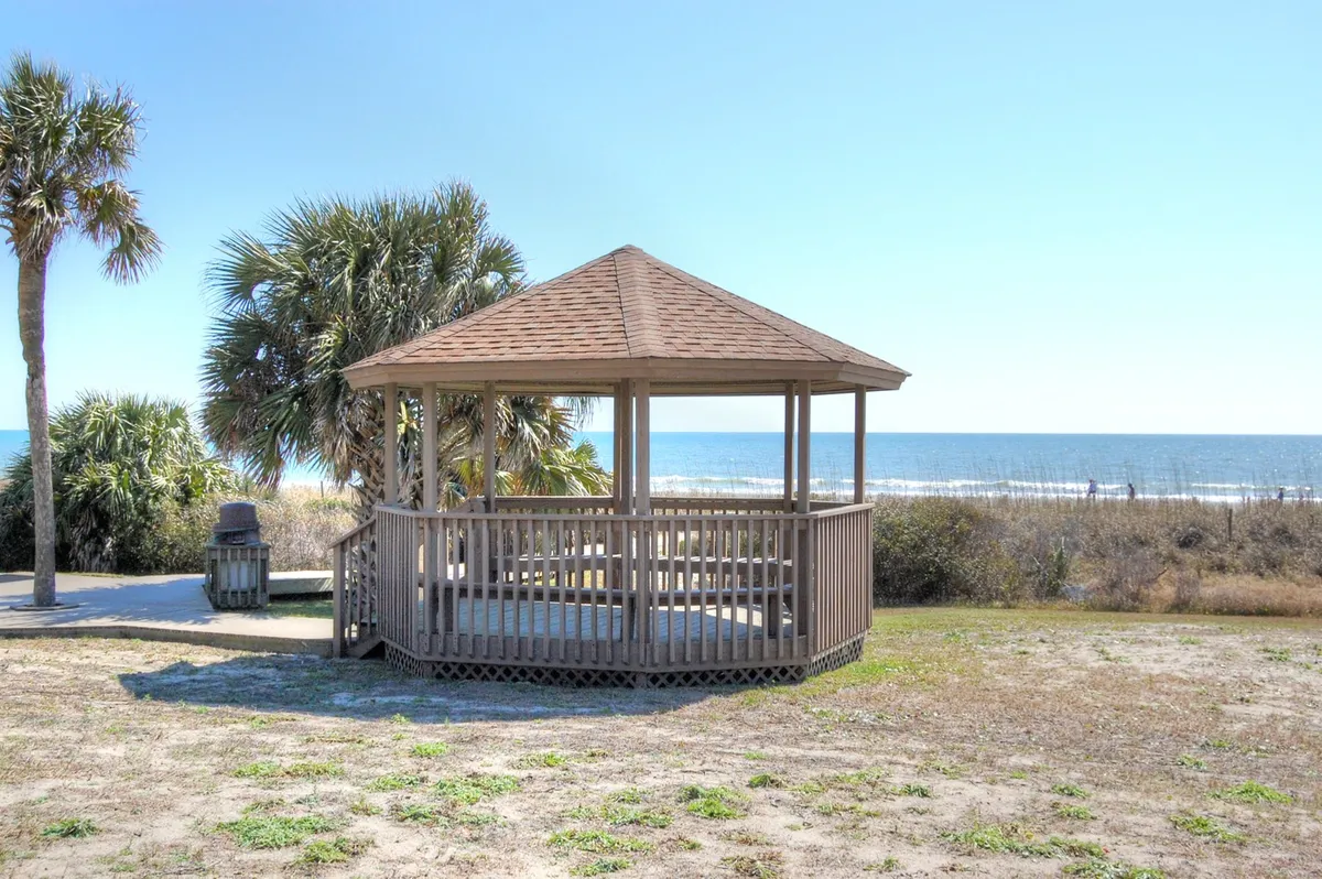This image shows a serene wooden gazebo overlooking the ocean, with palm trees gently framing the view. The tranquil setting invites relaxation and offers a romantic spot to watch sunsets or enjoy the ocean breeze.